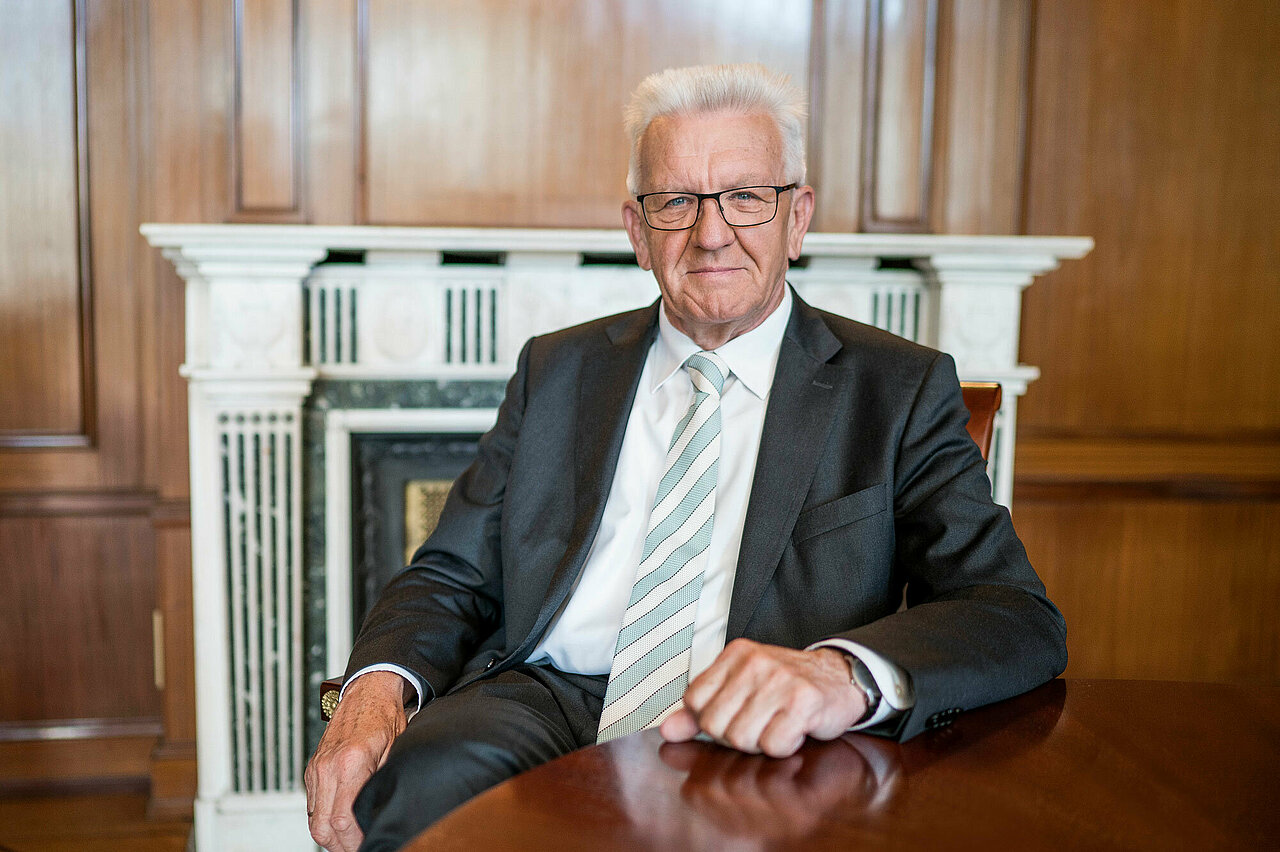 Portrait von Ministerpräsident Winfried Kretschmann im Sitzen.